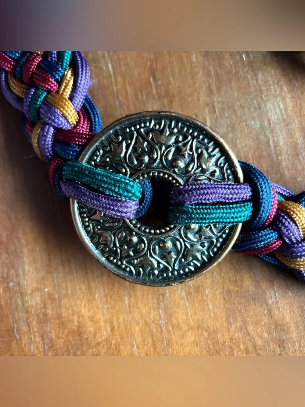 Multicoloured braided belt with decorative medallion